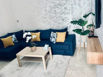 a blue couch in a living room with a table at Casa Chic Studio Apartment in Casablanca