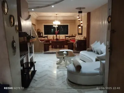 a living room with a couch and a table at Appartement de luxe Résidence Du Palais GHANDI in Casablanca