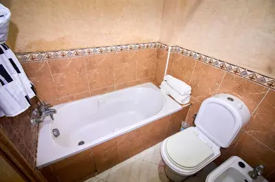 a bathroom with a tub and a toilet and a sink at Appartement de luxe Résidence Du Palais GHANDI in Casablanca