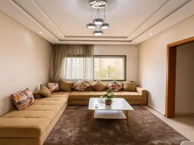 a living room with a couch and a table at Cosy ensoleillé 2CH proche de Mosquee hassan II et corniche in Casablanca