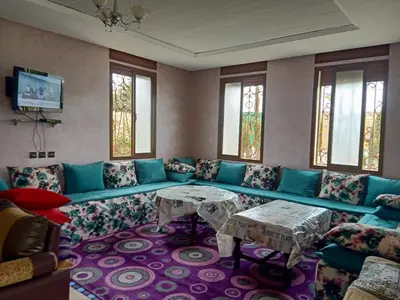 a living room with a blue couch and tables at Ferme