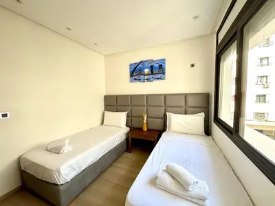 a bedroom with two beds and a window at 2br near TGV station in Rabat