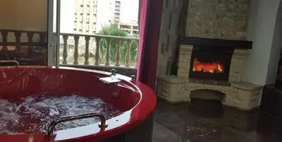 a red bath tub in a room with a fireplace at Appartements journaliers et mensuels in Aïn Chock