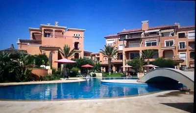 a large swimming pool in front of some buildings at Appartement du luxe au cœur du Golf in Bouznika