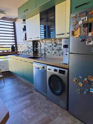 a kitchen with a washing machine and a refrigerator at Appartement moderne avec équipements de luxe in Maarif
