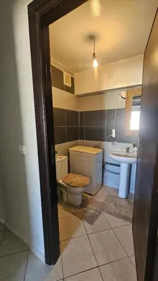 a bathroom with a toilet and a sink at appartement 75m2 avec piscine in Bouznika