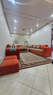 a living room with two couches and a rug at appartement 75m2 avec piscine in Bouznika
