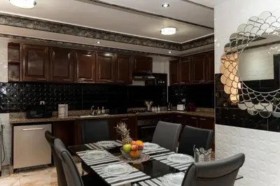 a kitchen with a table and chairs in a kitchen at Family apartment with balcony and Netflix in Temara