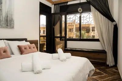 a bedroom with two white beds and a window at Family apartment with balcony and Netflix in Temara