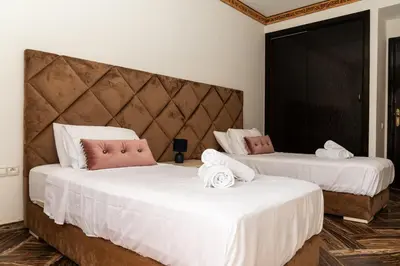two beds in a hotel room with white sheets at Family apartment with balcony and Netflix in Temara