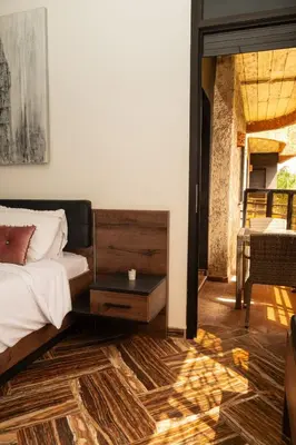 a bedroom with a bed and a table on a floor at Family apartment with balcony and Netflix in Temara