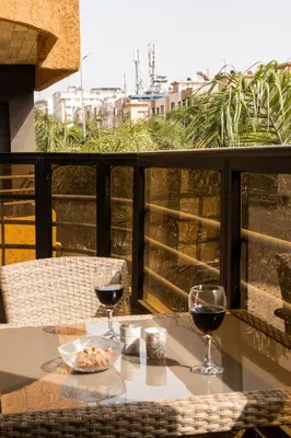 a table with two glasses of wine on a balcony at Family apartment with balcony and Netflix in Temara