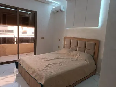 a bedroom with a bed in a room with a window at Jolie appartement Bouznika in Bouznika