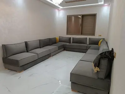 a living room with a couch and a table at Jolie appartement Bouznika in Bouznika