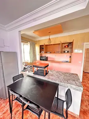 a kitchen with a table and chairs in a room at Apartment with swimming pool in O Ben Slimane