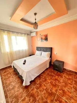 a bedroom with a bed in a room with orange walls at Apartment with swimming pool in O Ben Slimane
