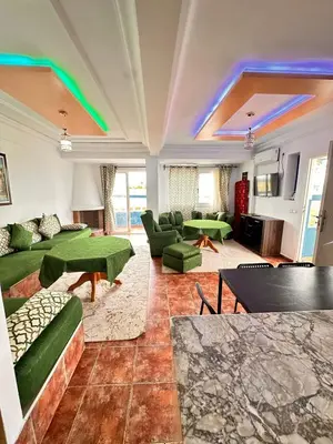 a large living room with green couches and tables at Apartment with swimming pool in O Ben Slimane