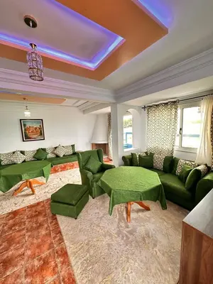 a living room with green couches and a couch at Apartment with swimming pool in O Ben Slimane