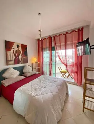 a bedroom with a large bed with red curtains at Sunshine in Casablanca