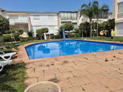 a large blue swimming pool in front of a building at Résidence balnéaire Les perles de Tamaris in Tamaris