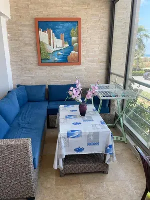 a living room with a blue couch and a table at Résidence balnéaire Les perles de Tamaris in Tamaris