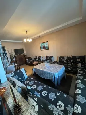a living room with a table and couches at Résidence balnéaire Les perles de Tamaris in Tamaris