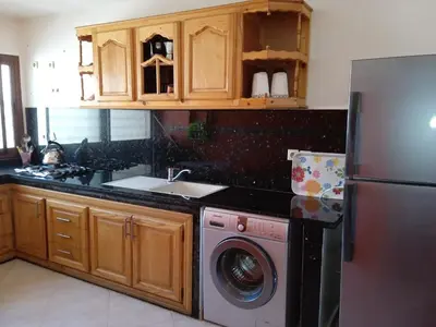 a kitchen with a refrigerator and a washing machine at The Bright House in Casablanca