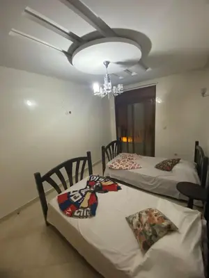 two beds in a room with a chandelier at The Bright House in Casablanca