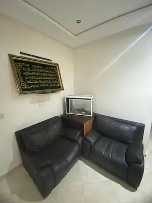 a living room with a leather couch and a mirror at The Bright House in Casablanca