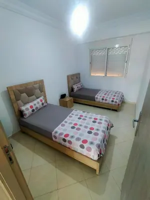a bedroom with two beds in a room at Appartement calme et confortable in Bouznika