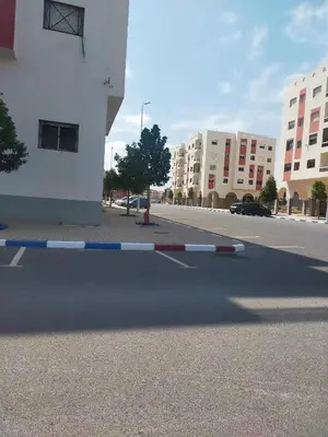 an empty street in a city with tall buildings at Appartement calme et confortable in Bouznika