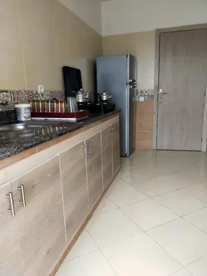 a kitchen with a refrigerator and a counter at Appartement calme et confortable in Bouznika