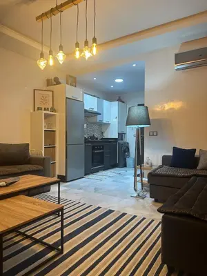 a living room with two couches and a kitchen at Studio bord de mer , La Siesta Beach Resort in Mohammedia