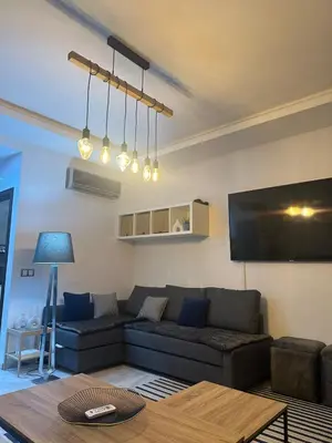 a living room with a couch and a tv at Studio bord de mer , La Siesta Beach Resort in Mohammedia