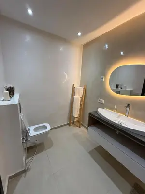 a bathroom with a sink and a toilet and a mirror at Elegant apartment Racine Bd AlMassira in Casablanca