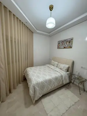 a bedroom with a bed in a room with curtains at Elegant apartment Racine Bd AlMassira in Casablanca