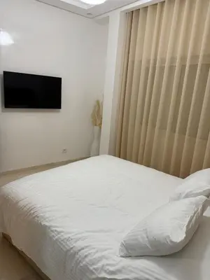 a bedroom with a bed with a television on the wall at Elegant apartment Racine Bd AlMassira in Casablanca