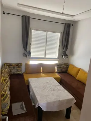 a living room with a couch and a table at Appartement Kettani bouznika in Bouznika
