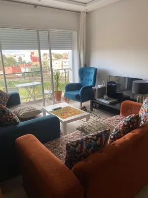 a living room with a couch and chairs and a table at Appartement Kettani bouznika in Bouznika