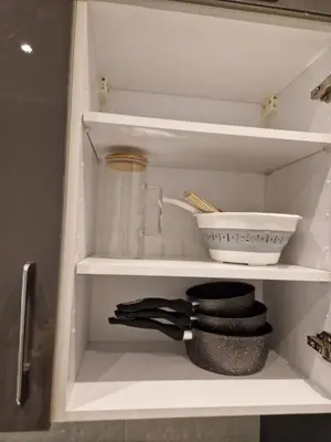 a kitchen cabinet with a shelf with a bowl and utensils at Chez Maud Skhirat-Rabat in Skhirat
