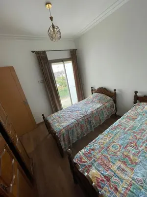 a bedroom with two beds and a window at APPART AMIR Belle Appartement avec pecine in Dar Bouazza