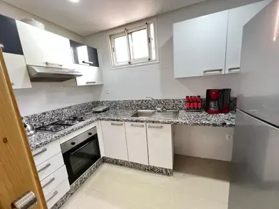 a kitchen with white cabinets and granite counter tops at Ola Blanca in Sidi Rahal
