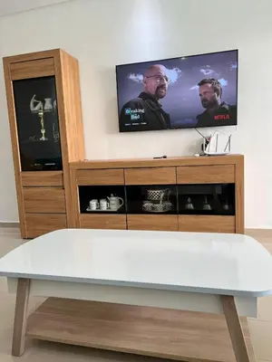 a tv sitting on top of a wooden entertainment center at Ola Blanca in Sidi Rahal