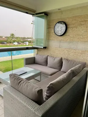 a living room with a couch and a clock on a wall at Ola Blanca in Sidi Rahal