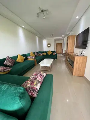 a living room with green couches and a tv at Ola Blanca in Sidi Rahal
