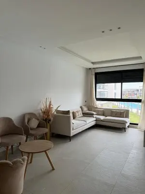 a living room with a couch and chairs and a table at Sidi Rahal Oceanic Appartement vue sur piscine in Sidi Rahal