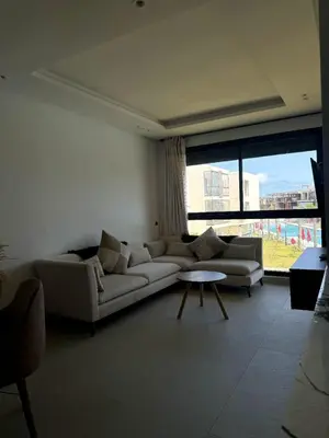 a living room with a couch and a table at Sidi Rahal Oceanic Appartement vue sur piscine in Sidi Rahal