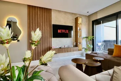 a living room with a couch and a tv at Luxurious and modern studio on Maarif-Franceville in Casablanca