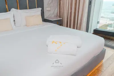 a bedroom with a bed with white sheets and pillows at TheBesty Ocean Apartment 2MBd- By Appart'Ayla in Casablanca