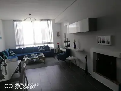 a living room with a blue couch and a fireplace at Appartement Résidence balnéaire Dar Al bahr in Sidi Rahal